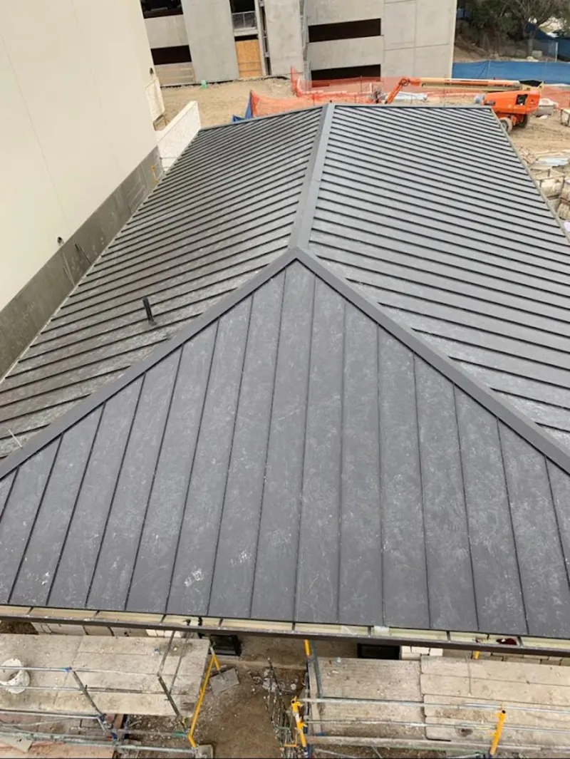 Commercial metal roof construction with crane equipment in Justice