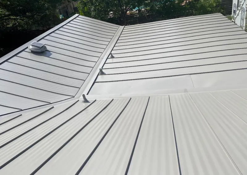 Solar attic fan installed on a metal roof for Roof Ventilation in Justice